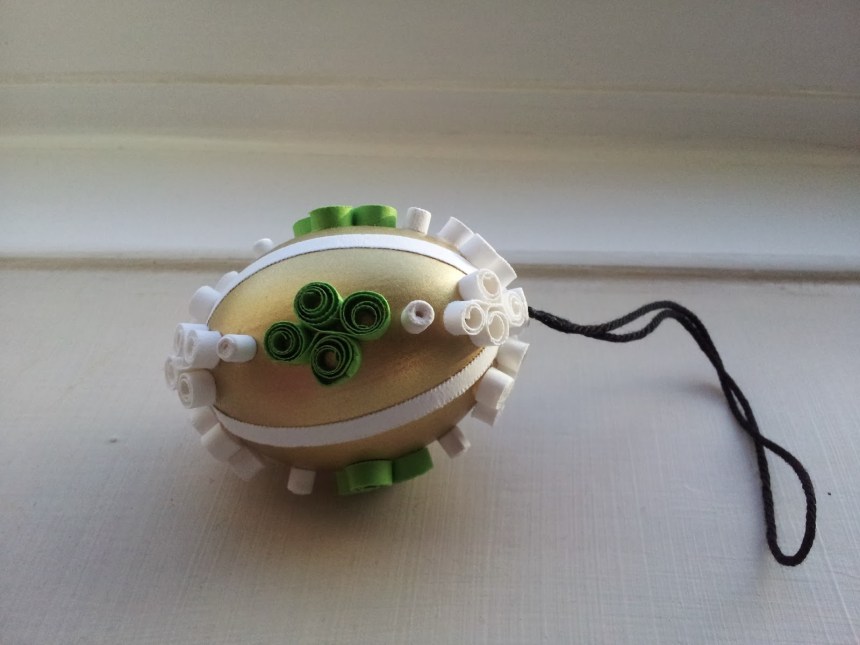 Gold bauble: quilled green and white filigree shapes; cotton string